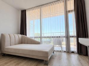 a living room with a couch and a large window at Hotel Jupiter in Sunny Beach