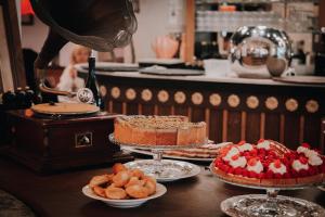 a table topped with cakes and other desserts on plates at Villa Henriette in Cabourg