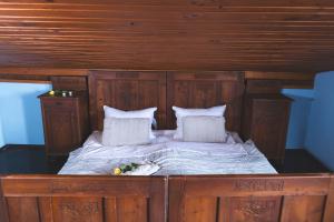 a wooden bed with two pillows and flowers on it at Home in Heaven I Historical Log House in Šentrupert