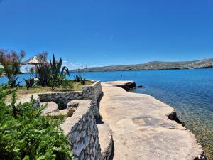 a stone wall next to a body of water at Apartment Perla in Dinjiška