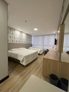 バウネアーリオ・コンボリウーにあるHotel das Américasのベッド2台とテレビのあるホテルの部屋 +97枚の写真