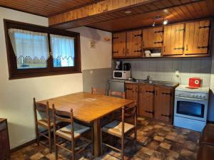 a kitchen with a wooden table and a table and chairs at Appartement proche stations de ski in Abondance