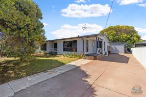 a small white house with a driveway at The Newby in Lancelin