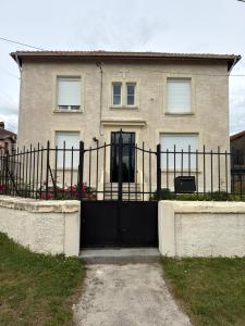 a house with a black gate in front of it at Les Croisés&Spa in Azannes-et-Soumazannes