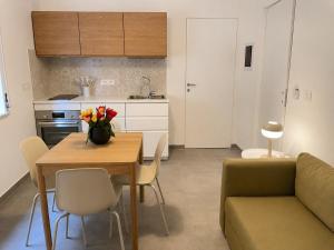 a kitchen and a table with a vase of flowers on it at Moon Apartments A in Soverato Marina