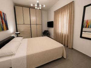 a bedroom with a large white bed and a window at Moon Apartments A in Soverato Marina +5 photos