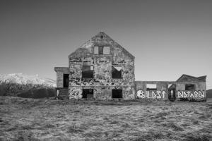 an old building with graffiti on it in a field at Hotel Langaholt in Langaholt