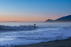 a person riding a wave on a surfboard in the ocean at Hotel Langaholt in Langaholt