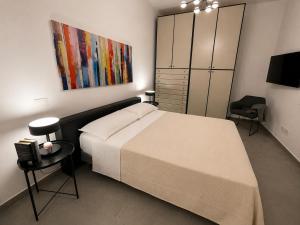 a bedroom with a bed and a painting on the wall at Moon Apartments A in Soverato Marina
