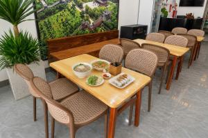 a row of tables and chairs with food on them at Khách Sạn Phố Cổ Ninh Bình NANA HOTEL in Kỳ Vĩ