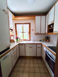 a small kitchen with white cabinets and a window at Appartements Haus am Römerbad Bad Kleinkirchheim in Bad Kleinkirchheim