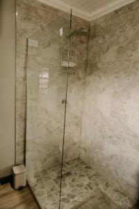 a shower with a glass door in a bathroom at Benedicto Farm in Welkom