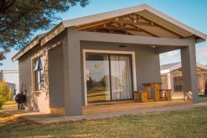 a small house with a large window in a yard at Benedicto Farm in Welkom