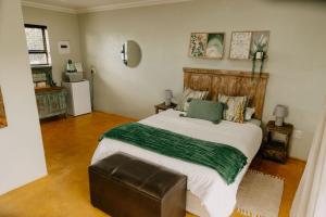 a bedroom with a large bed with a green blanket at Benedicto Farm in Welkom +17 photos