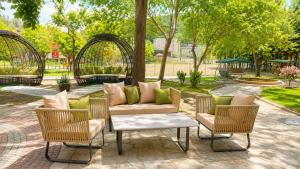 a patio with chairs and a couch and a table at Sandy Bay Resort - All Inclusive Private Beach Hotel in Sveti Vlas