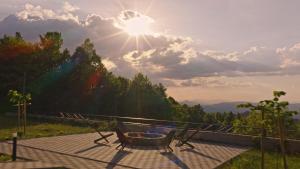 a table and chairs on a patio with the sun at Klek 77 Luxury Chalets near Jahorina in Paočići +81 photos