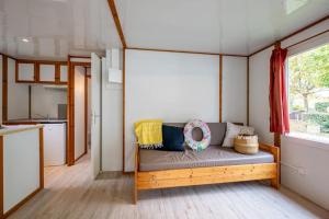 a living room with a couch in a tiny house at Camping 4 étoiles - Piscine - ccbfhbf in Badefols-sur-Dordogne