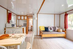 a living room with a couch and a kitchen at Camping 4 étoiles - Piscine - ccbfhbf in Badefols-sur-Dordogne +47 photos