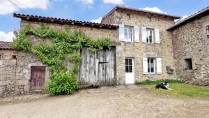 a dog sitting in front of a building at Les bonnes fontaines in Cieux