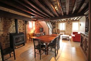 a living room with a wooden table and a fireplace at Les bonnes fontaines in Cieux