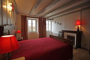 a bedroom with a red bed and a fireplace at Les bonnes fontaines in Cieux