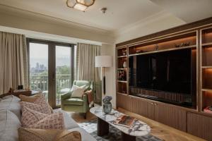 a living room with a large flat screen tv at The Athenaeum Hotel & Residences in London