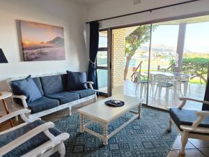 a living room with a couch and a table at Kleinmond Panorama Holidays in Kleinmond