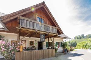 a large wooden building with a balcony at Weingut Peter Skoff - Domäne Kranachberg in Gamlitz