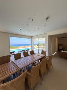 a dining room with a table and chairs and the ocean at Nireas Crystal in Aglantzia