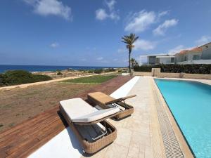 a pair of lounge chairs next to a swimming pool at Nireas Crystal in Aglantzia