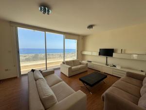 a living room with a couch and chairs and a television at Nireas Crystal in Aglantzia