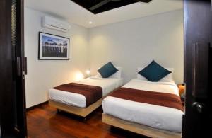two beds in a hotel room with at Villa Kejora 10 in Sanur