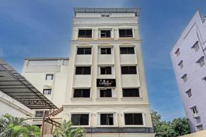 a tall white building with a sign on it at Hotel Vaishnavi in Hyderabad