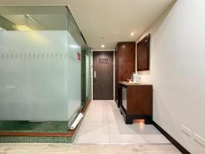 a bathroom with a glass shower and a sink at In One City Inn in Taichung +69 photos