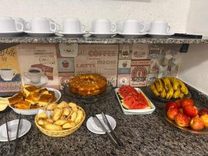 a counter with many different types of food on it at Pousada Saturnino in Hortolândia
