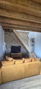 a living room with a couch and a staircase at Duplex Le Trèfle in Charmes-sur-lʼHerbasse