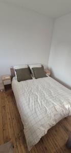a large bed in a room with two tables at Duplex Le Trèfle in Charmes-sur-lʼHerbasse