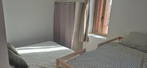 a bedroom with two beds and a window at Duplex Le Trèfle in Charmes-sur-lʼHerbasse +1 photo
