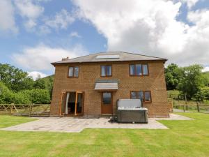 a brick house with a grill in a yard at Yr Onnen in Rhayader