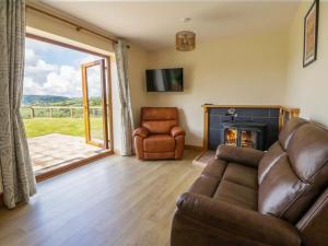 a living room with a couch and a fireplace at Yr Onnen in Rhayader