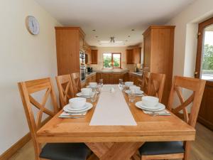 a dining room with a wooden table and chairs at Yr Onnen in Rhayader