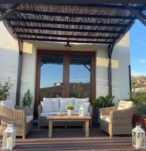 a patio with couches and a table on a deck at Maçussa Country House in Massuça