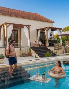 a man and woman standing in a swimming pool at Maçussa Country House in Massuça