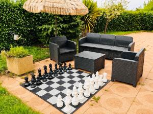 a chess board on a patio with a couch and an umbrella at Beausoleil SPA Villa L-Geneva, Lake, Mountains-Full Love Stay-SPA optional extra fee in Chens-sur-Léman