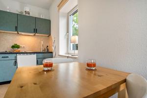 a kitchen with a wooden table with two glasses on it at Mohnrot - Fulgenhaus in Klein Bollhagen