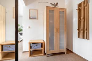 a dressing room with a wooden cabinet and a stool at Mohnrot - Fulgenhaus in Klein Bollhagen