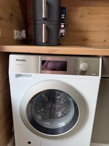 eine Waschmaschine mit einer Kaffeemaschine darauf in der Unterkunft Villa Cologne - Apartments & Monteursquartiere in Meckenheim bei Köln in Meckenheim + 42 Fotos