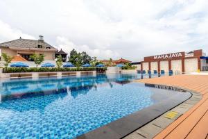 a swimming pool at a hotel with umbrellas at Maha Jaya Hotel Bali in Denpasar