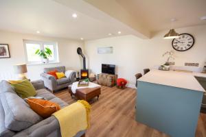 a kitchen and living room with a couch and a table at Cosy Hideaway I Couples Break I Private Estate in Newborough