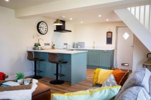 a kitchen and living room with a blue island in a room at Cosy Hideaway I Couples Break I Private Estate in Newborough
